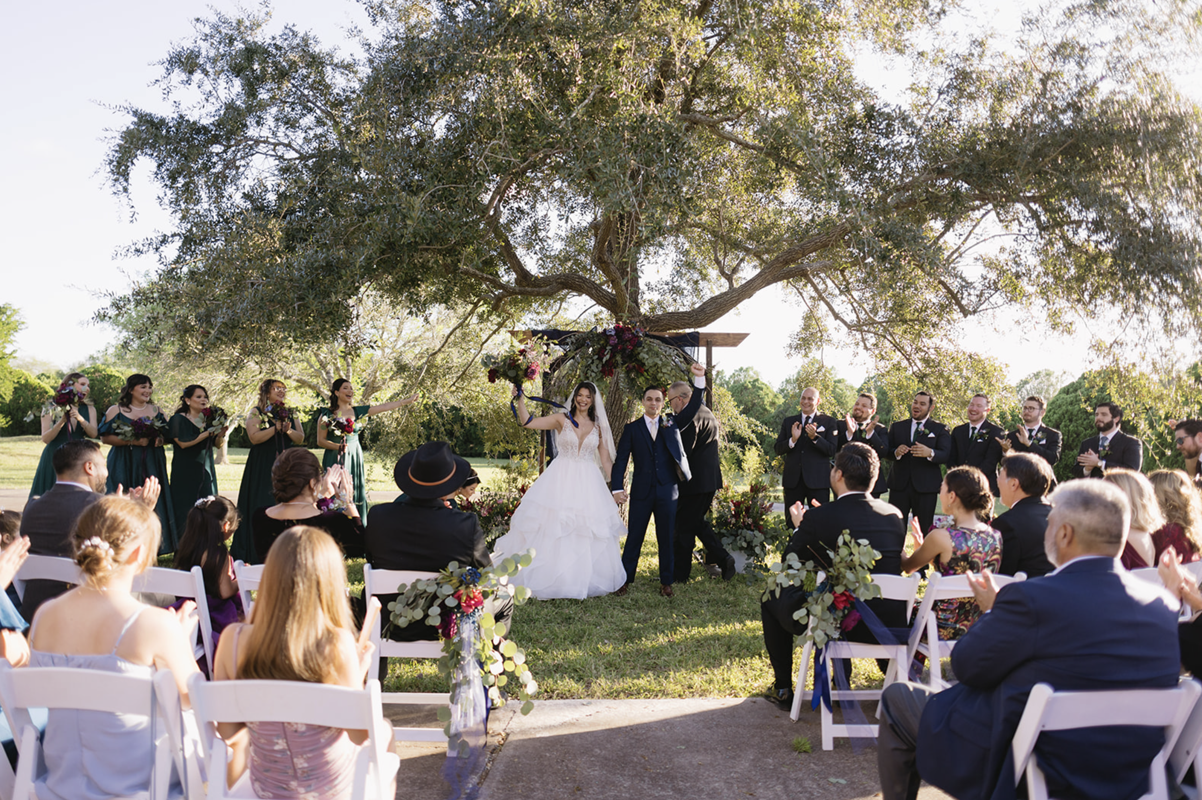 Bride and groom walking back down the aisle after their first kiss, surrounded by cheering guests — captured by San Antonio wedding photographer Angie Rich.