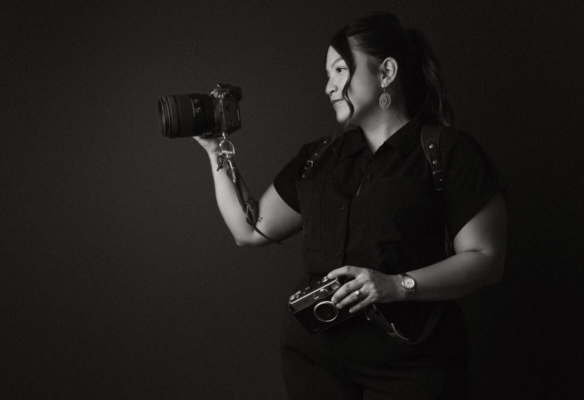 Professional photographer holding a DSLR camera, ready to capture photos, representing photography workflow and editing tools.