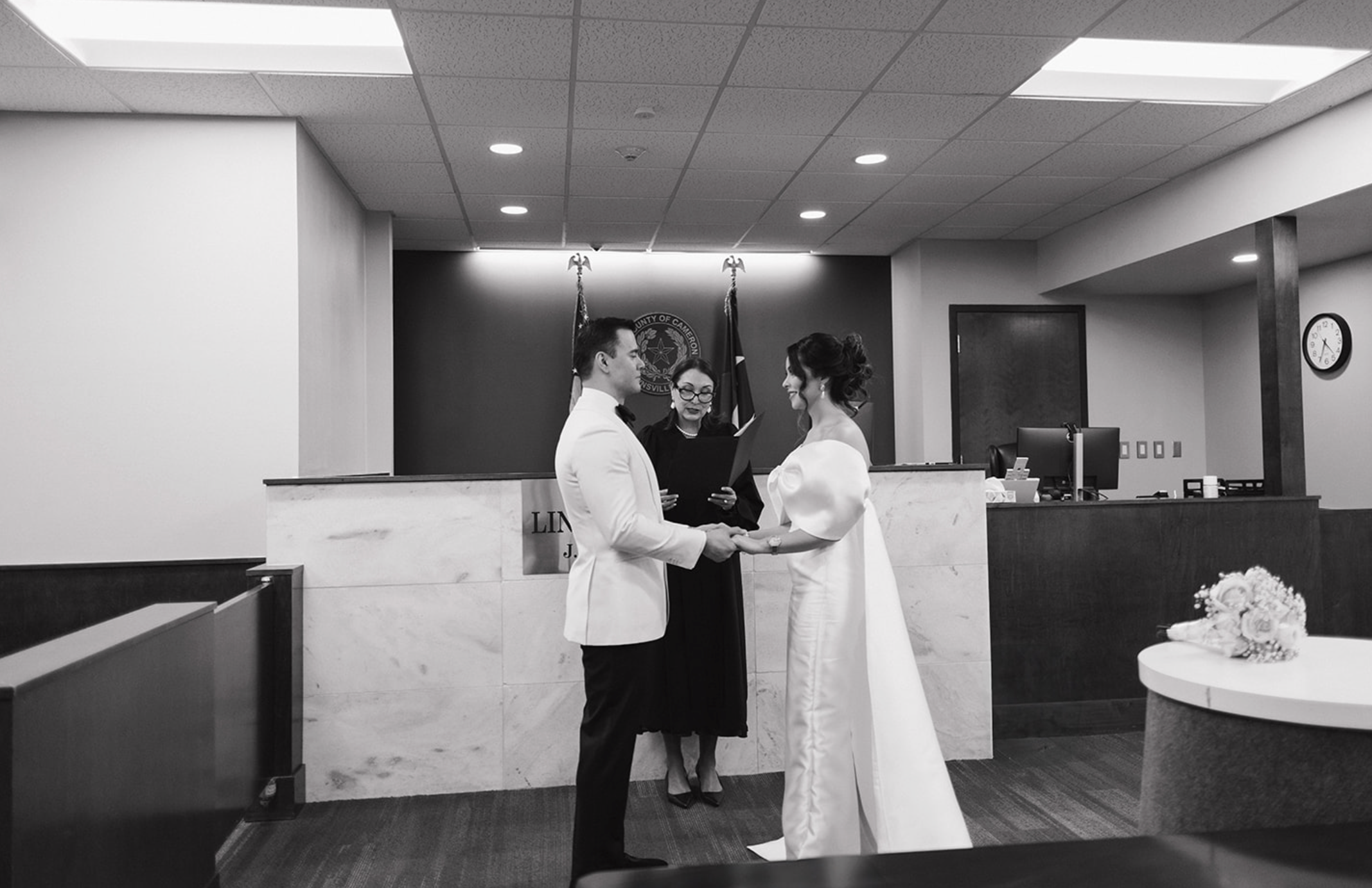 Couple standing in front of a judge at a San Antonio courthouse, exchanging vows during their intimate elopement ceremony, captured by wedding photographer Angie Rich.