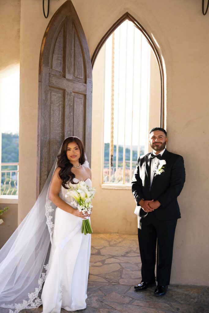 Bride and groom posing beneath the iconic chapel arch at Chapel Dulcinea in Austin, Texas.