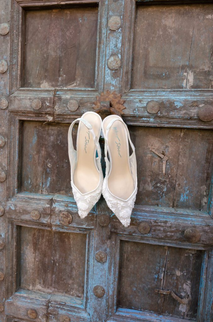 Bridal shoes displayed on a rustic wooden door before a Chapel Dulcinea wedding in Austin, Texas.
