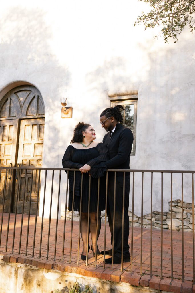 Couple sharing a romantic moment on the chapel balcony during an anniversary session at Lost Mission wedding venue in Spring Branch, Texas, photographed by Angie Rich Photography.