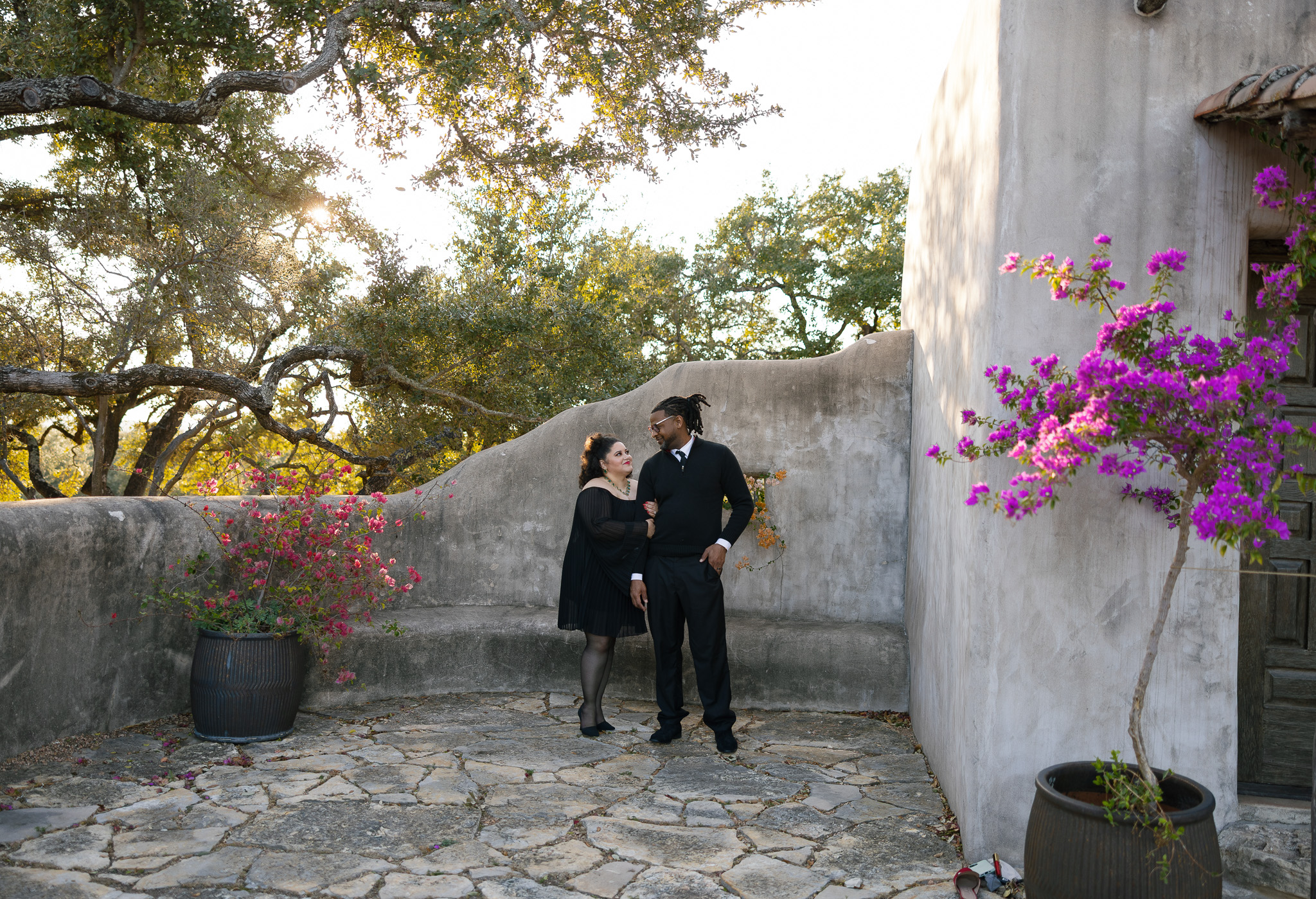 Couple sharing a quiet moment during their anniversary session at Lost Mission wedding venue in Spring Branch, Texas, surrounded by Spanish-inspired architecture and blooming bougainvillea.